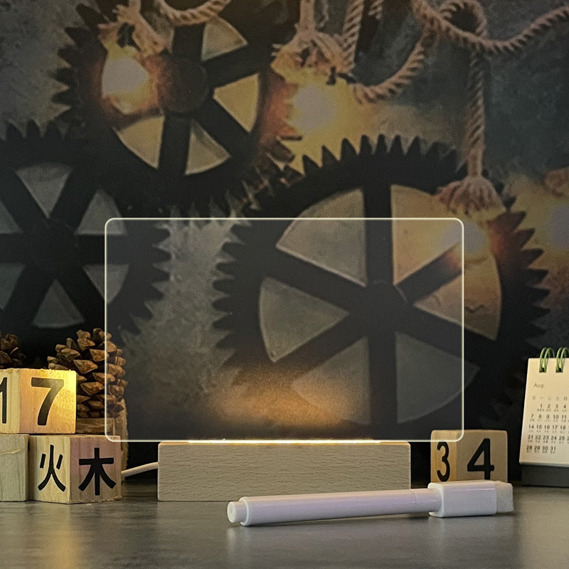 Rewritable neon note board in its horizontal landscape shape, glowing warm-white in a wooden stand beside its marker pen