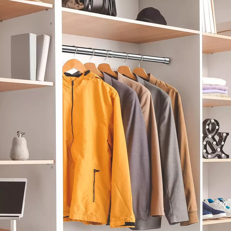 The rail fixed between the sides of a wardrobe, holding jackets on wooden hangers, with shelves either side.