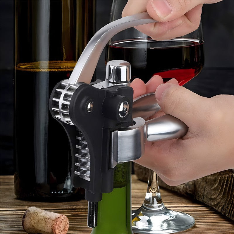 Hands using the lever corkscrew to open a bottle of wine, a poured glass of red and the removed cork alongside