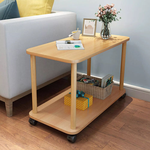 The same two-tier side table on wheels standing beside a sofa in a living room, with a cup, an open magazine, a picture frame and a vase of flowers on the top and a basket and a gift box on the shelf below. The items shown are not included.