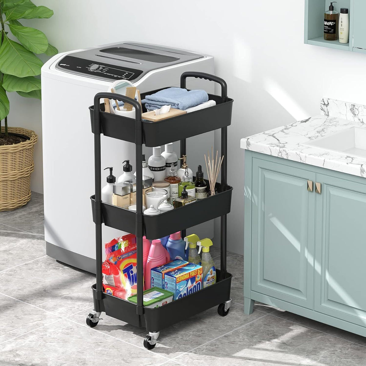 The black trolley in a bathroom beside a washing machine, holding toiletries and cleaning bottles.
